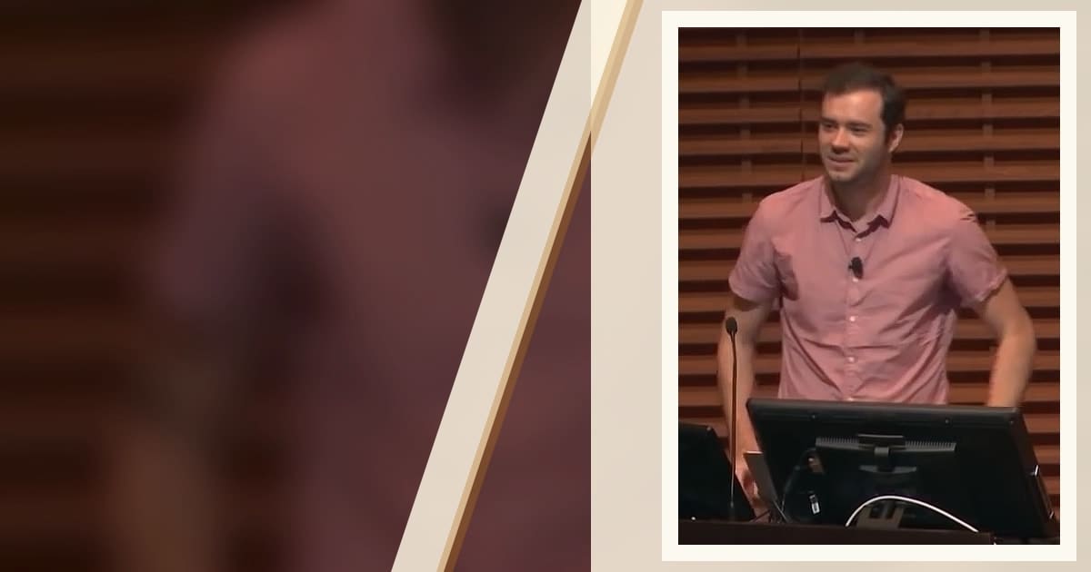 Andrej Karpathy speaking at a lectern during an AI lecture.