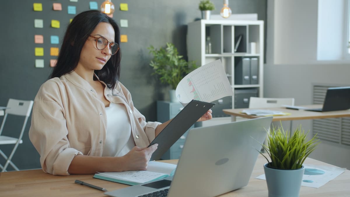 A professional reviewing a printed report at an office desk
