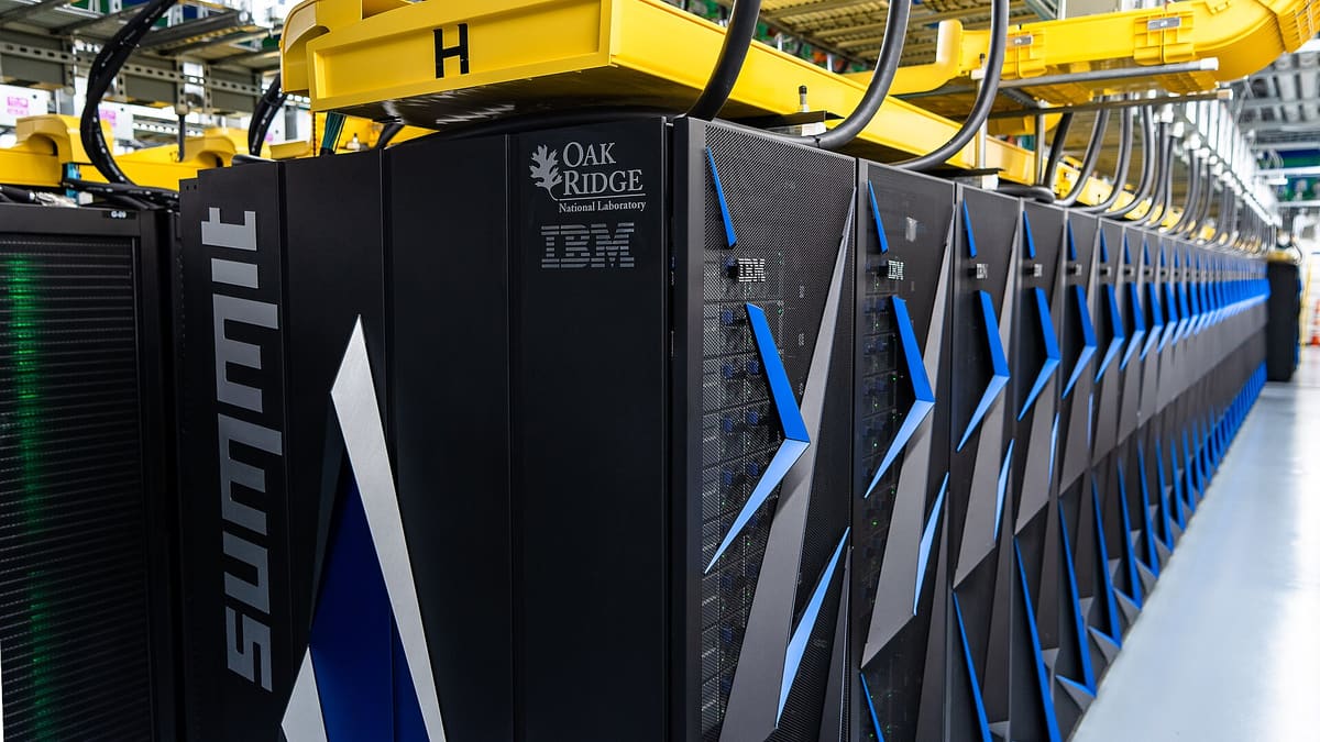 Rows of black Summit supercomputer racks at Oak Ridge National Laboratory — the class of infrastructure that serves large language models, where every token is metered.